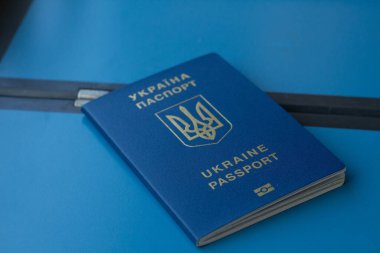 Ahşap arka planda Ukrayna bayrağı olan pasaport, seyahat kavramı