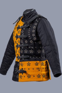 İki Tonluk Ortaçağ Brigandine Zırhı ve Buckles. Benzersiz gövde koruması karşıt sarı ve siyah paneller dekoratif perçinler ve deri kayış kapakları ile.