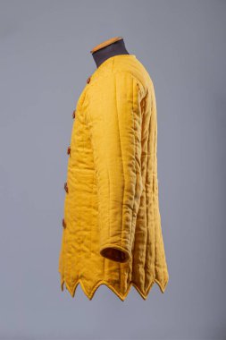 Sarı yastıklı Gambeson ceketi. Deri kayışlı kapaklı orta çağ yorganı..