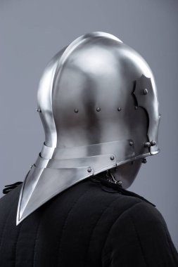 Ortaçağ kaskı, güneşlik ve içecekle birlikte. Parlak gümüş bir ortaçağ salatası kaskında menteşeli bir güneşlik ve boynunu koruyan küçük perçinler bulunur..