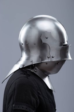 Ortaçağ kaskı, güneşlik ve içecekle birlikte. Parlak gümüş bir ortaçağ salatası kaskında menteşeli bir güneşlik ve boynunu koruyan küçük perçinler bulunur..