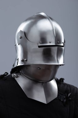 Ortaçağ kaskı, güneşlik ve içecekle birlikte. Parlak gümüş bir ortaçağ salatası kaskında menteşeli bir güneşlik ve boynunu koruyan küçük perçinler bulunur..