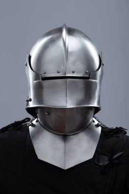 Ortaçağ kaskı, güneşlik ve içecekle birlikte. Parlak gümüş bir ortaçağ salatası kaskında menteşeli bir güneşlik ve boynunu koruyan küçük perçinler bulunur..