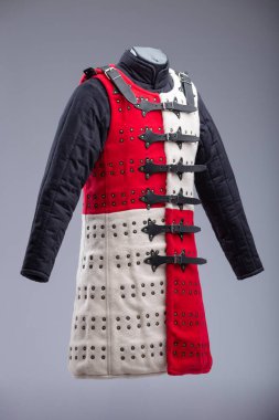 Kırmızı ve Beyaz Brigandine Zırhı, Studs ve Black Straps. Bu resim, biri kırmızı diğeri beyaz olmak üzere iki yarıya bölünmüş bir Brigandine zırhını gösteriyor. Sıraları küçük pirinç renkli çiviler içeriyor ve çoklu siyah ile korunuyor 