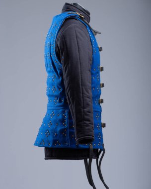 Parlak Mavi Brigandine Zırhı, Studs ve Black Straps. Bu resim parlak mavi bir brigandin zırhı gösteriyor. Sıraları küçük pirinç renkli çiviler ve çoklu siyah deri kayışlar ve gümüş tokalarla korunuyor..