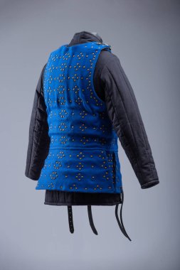 Parlak Mavi Brigandine Zırhı, Studs ve Black Straps. Bu resim parlak mavi bir brigandin zırhı gösteriyor. Sıraları küçük pirinç renkli çiviler ve çoklu siyah deri kayışlar ve gümüş tokalarla korunuyor..