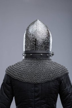 Dark Metal Miğfer, Sivri uçlu ve Faceplakalı. Bu resim, yüzün alt kısmını kaplayan ve görüş için çeşitli yatay yarıklara sahip koyu metal bir miğfer ve bir yüz plakası göstermektedir. Bir zincirli tasma hel 'e bağlıdır.