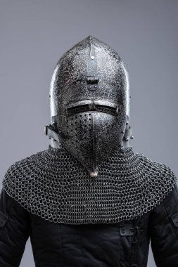 Dark Metal Miğfer, Sivri uçlu ve Faceplakalı. Bu resim, yüzün alt kısmını kaplayan ve görüş için çeşitli yatay yarıklara sahip koyu metal bir miğfer ve bir yüz plakası göstermektedir. Bir zincirli tasma hel 'e bağlıdır.