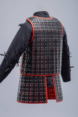 Siyah Deri Samuray Zırhı ve Kırmızı Trim. Katmanlı deri tabaklar ve canlı kırmızı aksanlı geleneksel Japon savaşçı giysisi..