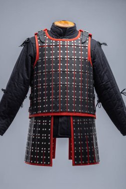 Siyah Deri Samuray Zırhı ve Kırmızı Trim. Katmanlı deri tabaklar ve canlı kırmızı aksanlı geleneksel Japon savaşçı giysisi..