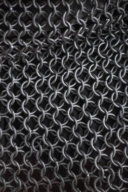 Esnek Ortaçağ Zincir Postası 'nın Detaylı Yakın Çekimi. Örülmüş metal halkaların karmaşık deseni dayanıklı koruyucu bir giysi oluşturuyor..