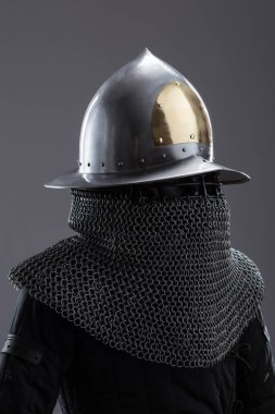 Altın aksanlı ve zincirli zarif Ortaçağ Miğferi. Cilalı bir kapanış, altın bir detay ve zincirli posta içeren sofistike bir kafa koruması..