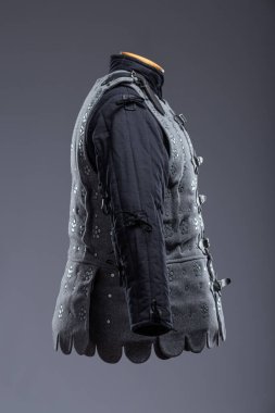 Deri kayışlı gri Ortaçağ Brigandine Zırhı. Bu gri brigandin, üst üste binen metal plakaların kumaş tabanına perçinlenmiş ve deri kayışlarla güvence altına alınmış halidir..