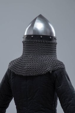 Burun Barı 'ndan Gümüş Norman Miğferi. Bu görüntü, konik şekliyle karakterize edilmiş parlak gümüş bir Norman miğferi ve yüz koruması için ön tarafa uzanan belirgin bir burun barı gösteriyor. Ayrıca altında görünen bir posta kapağı var..