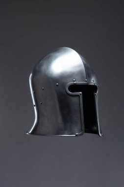 Açık Yüzlü Gümüş Ortaçağ Miğferi. Bu resim, kenarları yuvarlak ve küçük perçin içeren, açık yüzlü parlak gümüş bir miğfer sergiliyor..