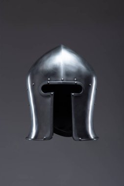 Açık Yüzlü Gümüş Ortaçağ Miğferi. Bu resim, kenarları yuvarlak ve küçük perçin içeren, açık yüzlü parlak gümüş bir miğfer sergiliyor..