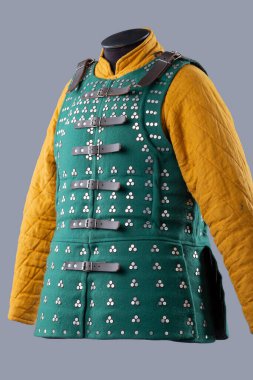 Koyu yeşil Brigandine Zırhı ve Studded Destern. Bu resim koyu yeşil bir brigandin zırhı gösteriyor, üçlü gruplar halinde dizilmiş küçük gümüş çiviler ve siyah deri kayışlar ve tokalarla korunuyor..