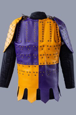 Studs and Buckles 'lı renkli Brigandine Zırhı. Bu resim canlı bir Brigandine zırhı gösteriyor, mor ve sarı deri bölümlerin karışımı çivili ve siyah kayışlar ve tokalarla korunuyor..