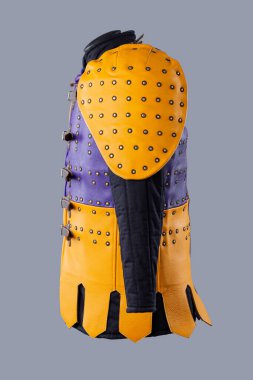 Studs and Buckles 'lı renkli Brigandine Zırhı. Bu resim canlı bir Brigandine zırhı gösteriyor, mor ve sarı deri bölümlerin karışımı çivili ve siyah kayışlar ve tokalarla korunuyor..