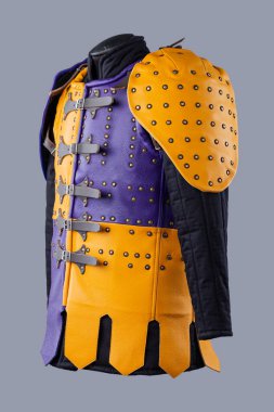 Studs and Buckles 'lı renkli Brigandine Zırhı. Bu resim canlı bir Brigandine zırhı gösteriyor, mor ve sarı deri bölümlerin karışımı çivili ve siyah kayışlar ve tokalarla korunuyor..