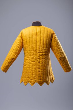 Sarı yastıklı Gambeson ceketi. Deri kayışlı kapaklı orta çağ yorganı..