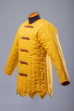 Sarı yastıklı Gambeson ceketi. Deri kayışlı kapaklı orta çağ yorganı..