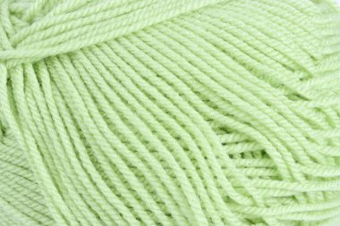 Yumuşak dokusunu, bükülmüş liflerini ve canlı rengini vurgulayan iplik topunun yakın çekimi örgü örmeye ya da örmeye hazırdır.