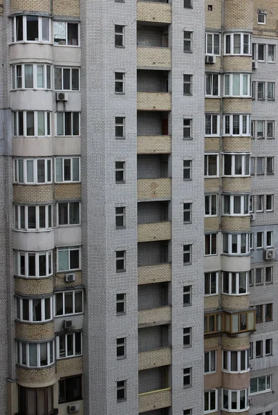 一座由白色砖建成的带小公寓立柱照片的预算高层建筑的立面 — 图库照片