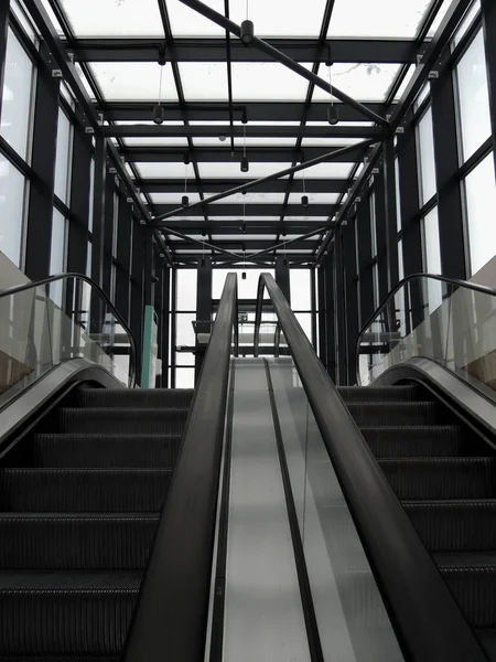 A pair of escalators with glass railing from underground floor to exit stock photo for vertical story