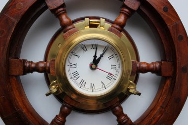 Yuvarlak bir ahşap çerçevenin ortasında klasik saat. 