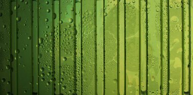 Water drops on green plastic panel texture background 