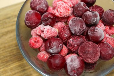 Ahşap borsada dondurulmuş meyveli meyvelerin karıştırılmış fotoğrafının yakın çekimi.