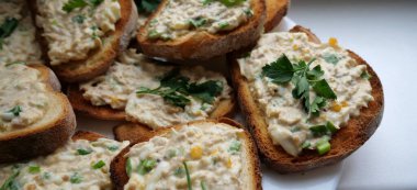 Yumurta salatası, yeşil soğan ve maydanoz manzaralı kızarmış ekmeklerin detaylı fotoğrafı.