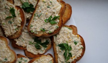 Beyaz tabak, tost sandviçli yumurta salatası, mayonez ve soğanlı.