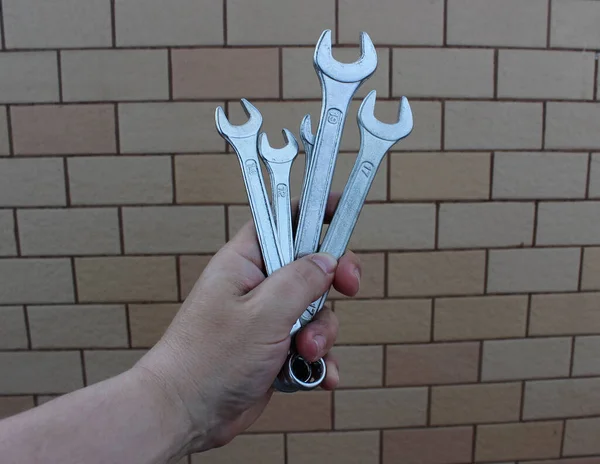 Різного Розміру Сталеві Шестигранні Гайкові Ключі Руці Людини Фоні Цегли — стокове фото