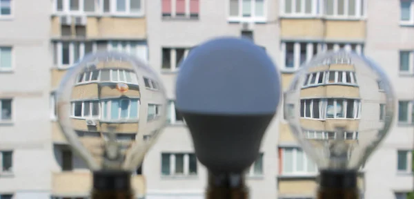 两根灯丝灯泡和现代Led灯背景下的公寓楼的软焦点概念照片 — 图库照片