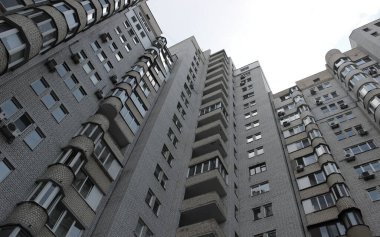 Beyaz tuğladan yapılmış, yerden manzaralı, küçük apartman manzaralı, yüksek bütçeli bir bina. 