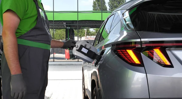 ガソリンスタンドで給油労働者が車のガソリンタンクフラップの詳細ストックフォトを開きます — ストック写真
