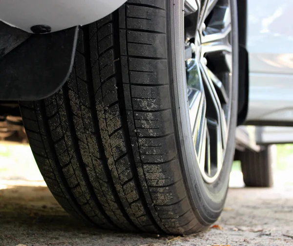 Kumsala yakın manzaralı, kapısı açık beyaz bir arabanın ön tekerleği. 