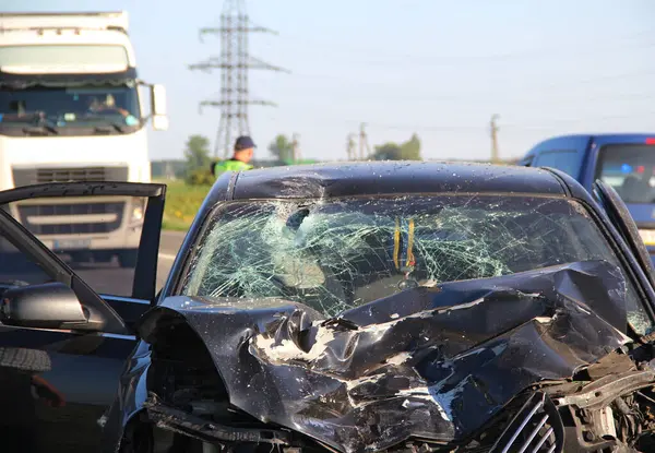 The mangled front part of a car after a head-on crash accident with a truck