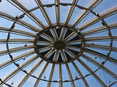 Tavan ışıkları olan yuvarlak cam bir çatının metal yapısı 