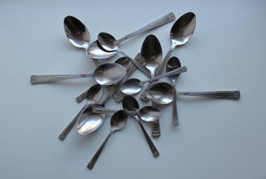 Beyaz plastik kesim tahtasına yığınla kaşık ve tatlı kaşığı. Utensils Yeme Konsepti Tasarımı 