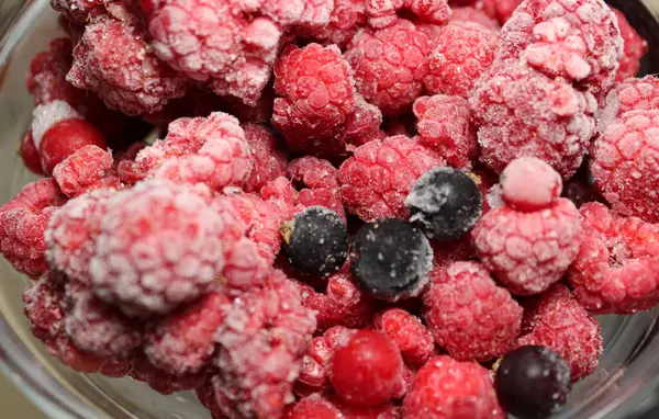 Kırmızı ve siyah akıntı ile karıştırılmış donmuş ahududu meyvelerinin detaylı görünümü 