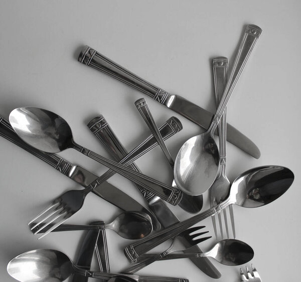 Смесь серебряных вилок, ножей и ложек для съедания крупным планом. Фото для фона концепции столовых приборов