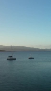 Çapalı yelkenli panoramik manzaralı Güzel Deniz Koyu 'nun dikey videosu
