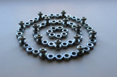 Rings made of steel color nuts and bolts screwed into them at regular intervals angle view stock photo for mechanical backgrounds clipart