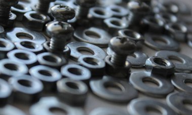 İplik somunları, çamaşır makineleri ve vidalar beyaz makro resimde izole edilmiş.