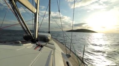 Gün batımında dalgalı bir denizde yelken açan bir yelkenlinin güvertesindeki lastik filika. Yelkenli eğlence ve etkinlik Tam HD stok video
