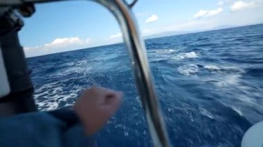 Bir adamın elleri, son sürat bir yatın kıçından denize giden bir oltayı düzleştirir. Tekne stoğundan balık avı Full HD video 