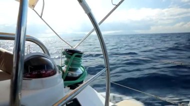 Direksiyon simidi ve deniz pusulasından yelkenli bir yatın kenarındaki dalgalara bak. Yat gezisi videosu HD kalitesinde